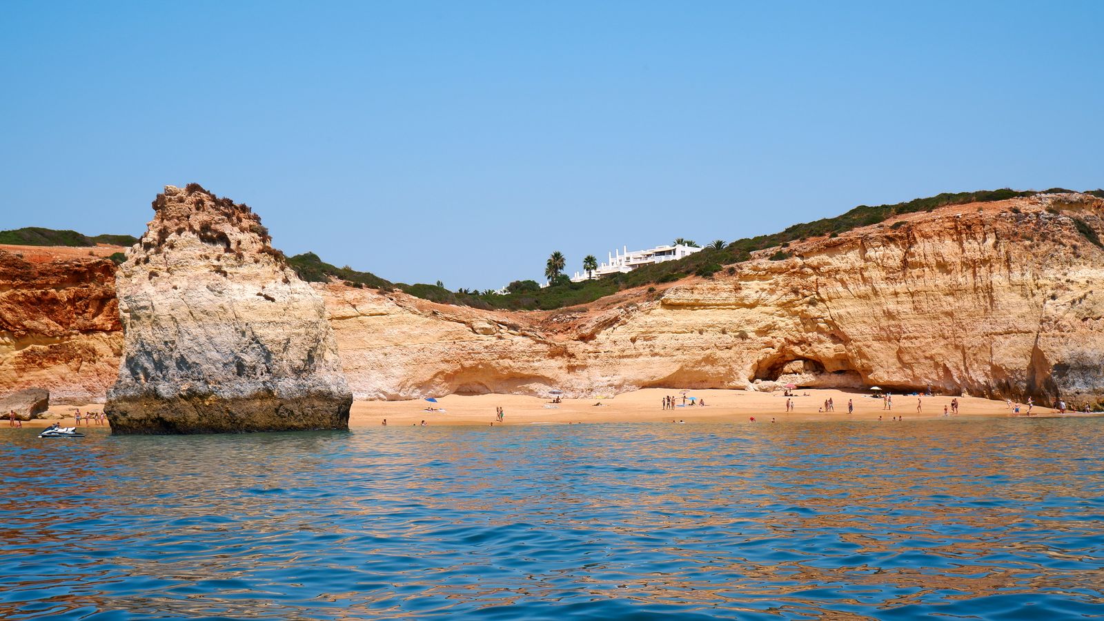 Aerial view of a cliff-lined cove beach on the Algarve coast, Portugal