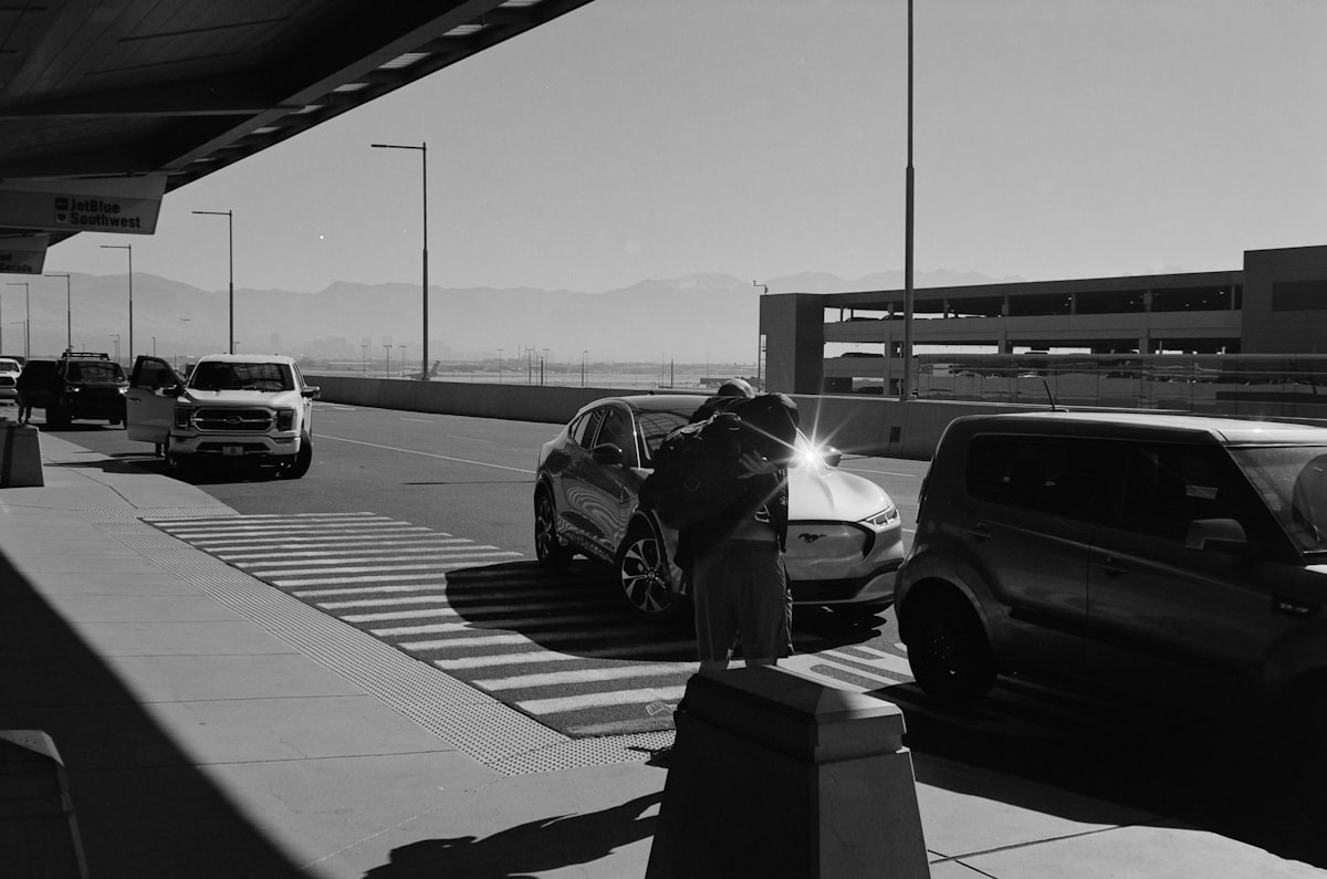 Dark sedan exiting a sunny European airport