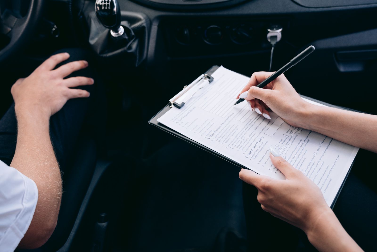 Insurance policy document with a small car model and magnifying glass