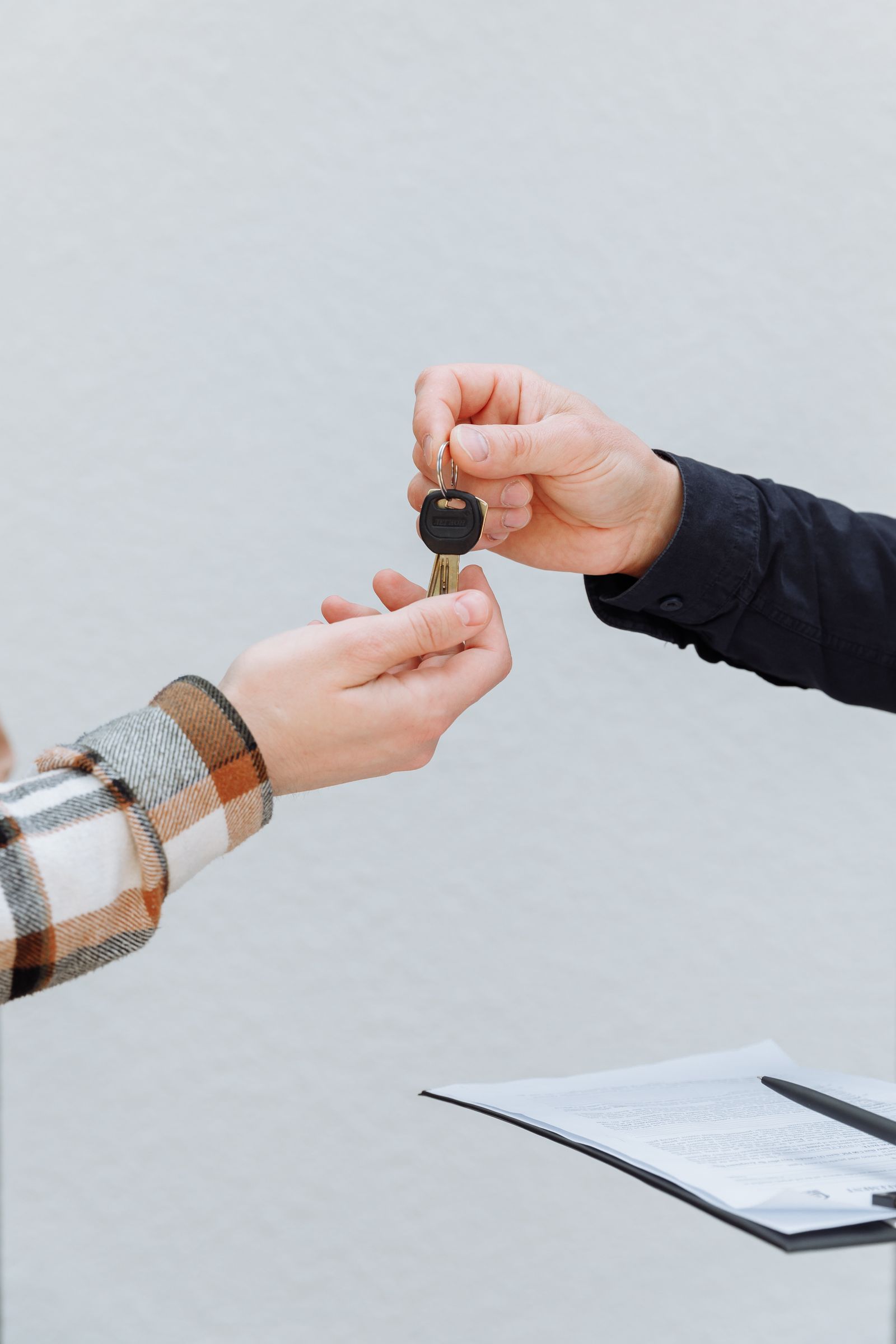 Rental car keys being handed over next to a signed contract