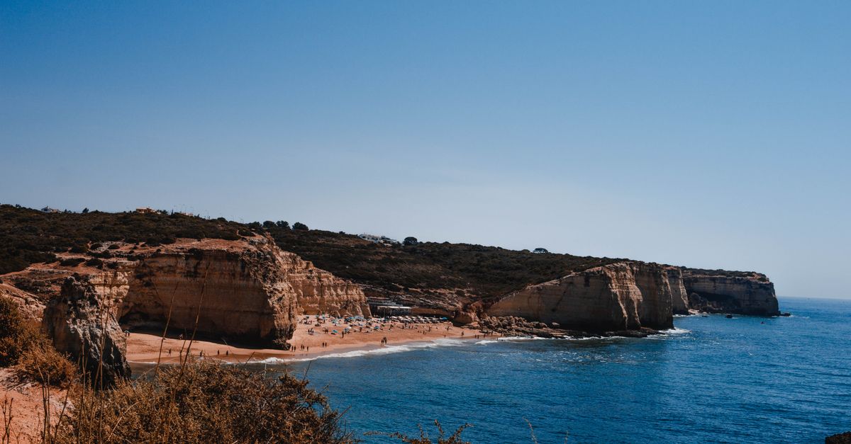 A car on a coastal road above the cliffs of the Algarve in southern Portugal on a sunny day