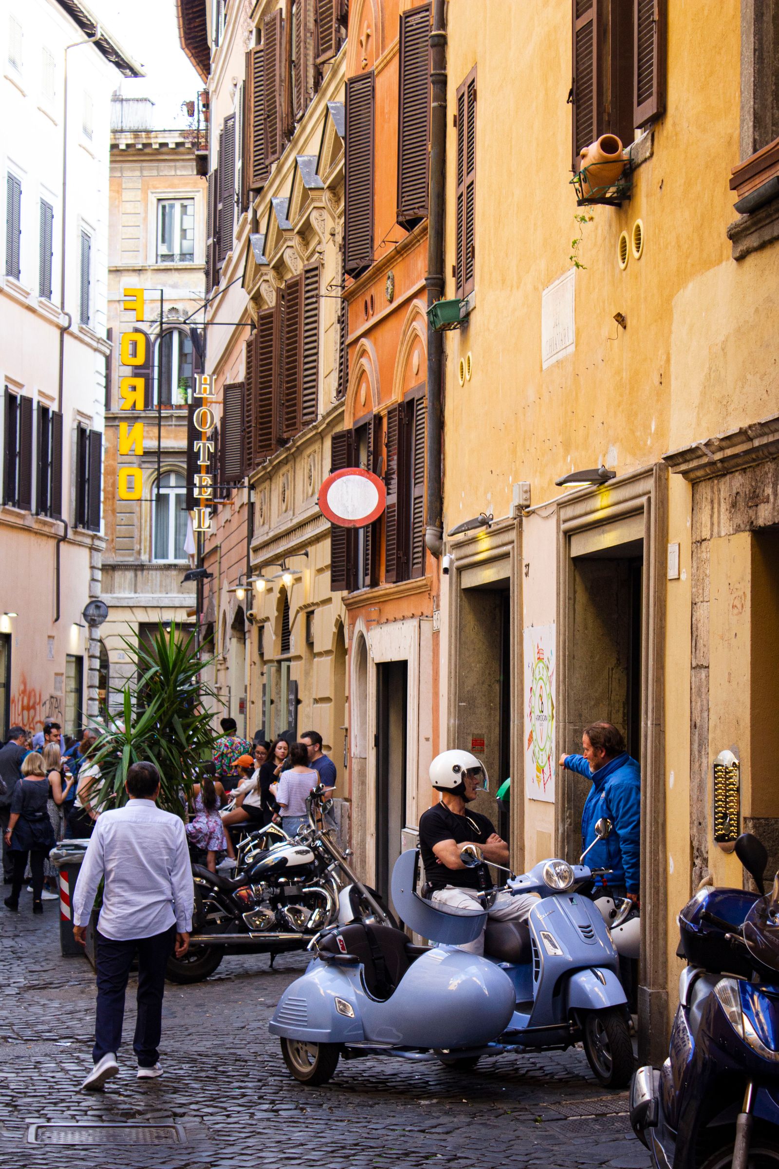 Vespa scooters parked on a narrow cobblestone street in Rome