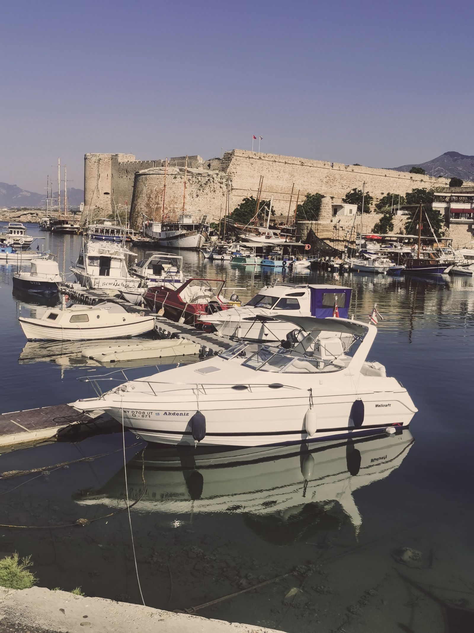 Rent a Car in Kyrenia: Fishing boats and yachts moored in Kyrenia harbour beneath the medieval Kyrenia Castle, Northern Cyprus