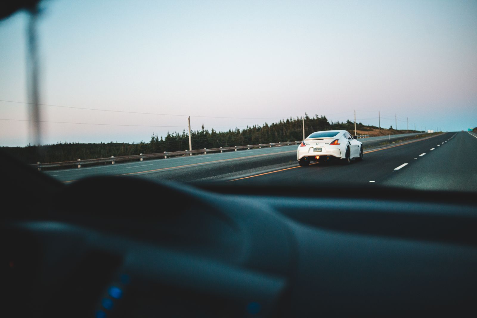 Vue depuis l'habitacle d'une voiture sur une route ouverte au crépuscule