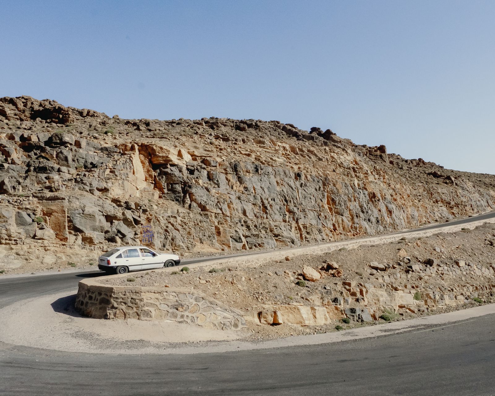 Voiture de location dans un virage en épingle sur une route de montagne au Maroc