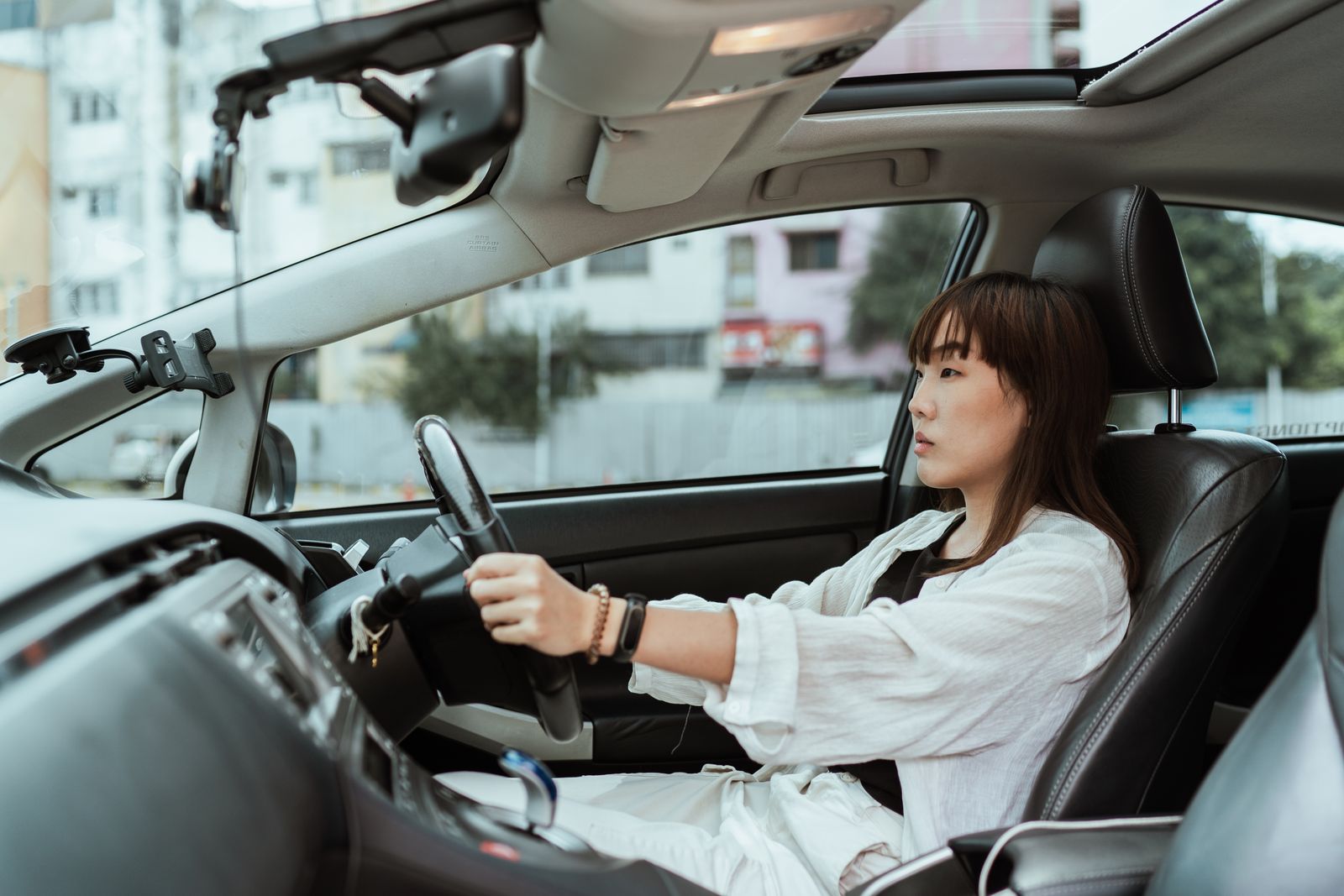 Jeune femme au volant d'une voiture de location en ville