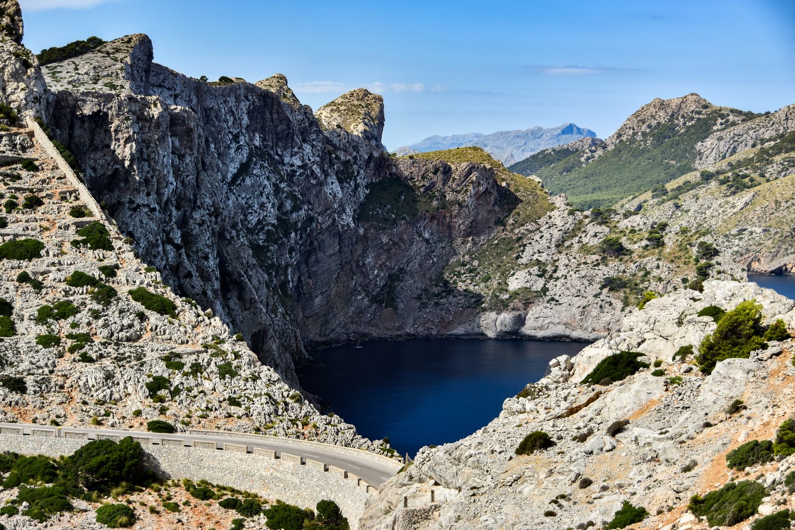 Die Küstenstrasse zum Cap Formentor auf Mallorca, die sich an steilen Kalkfelsen über einer tiefblauen Bucht entlangzieht