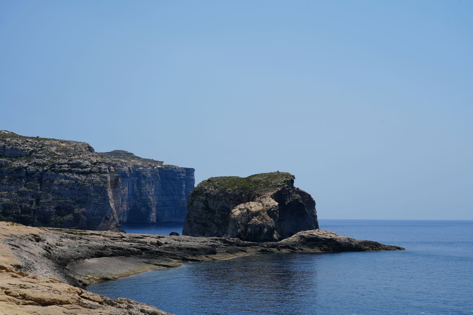 Acantilados de Gozo junto a Dwejra con el peñón de Fungus Rock sobre un mar azul intenso