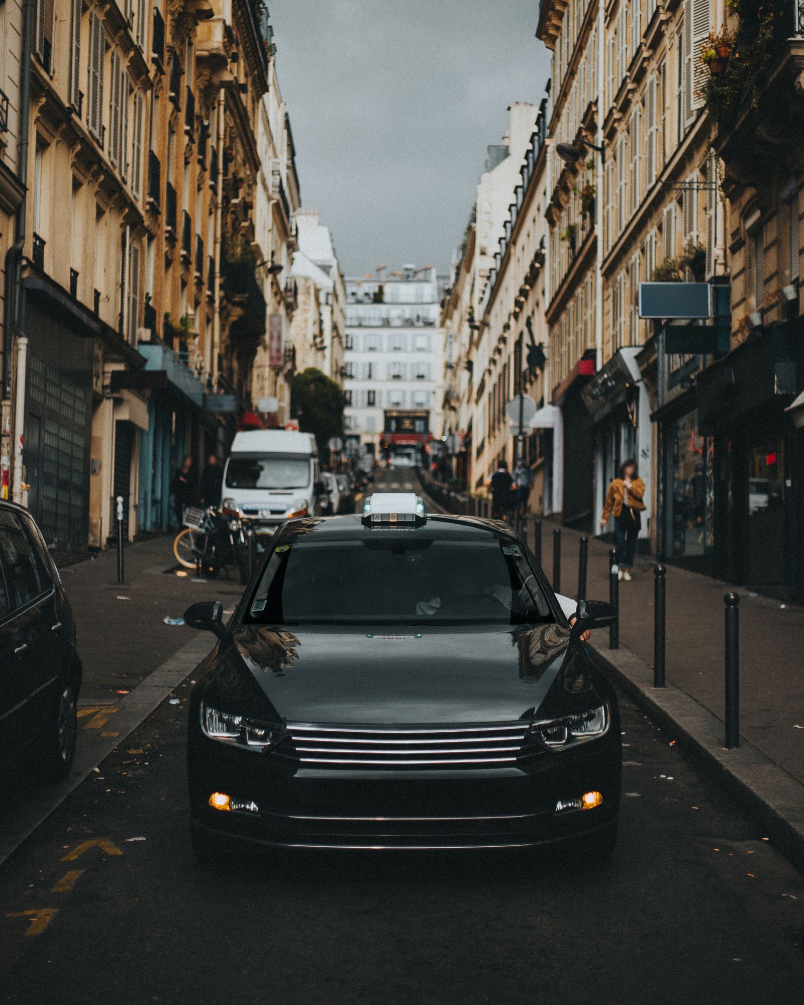 Auto in einer engen Innenstadtstraße von Paris, umgeben von historischen Gebäuden
