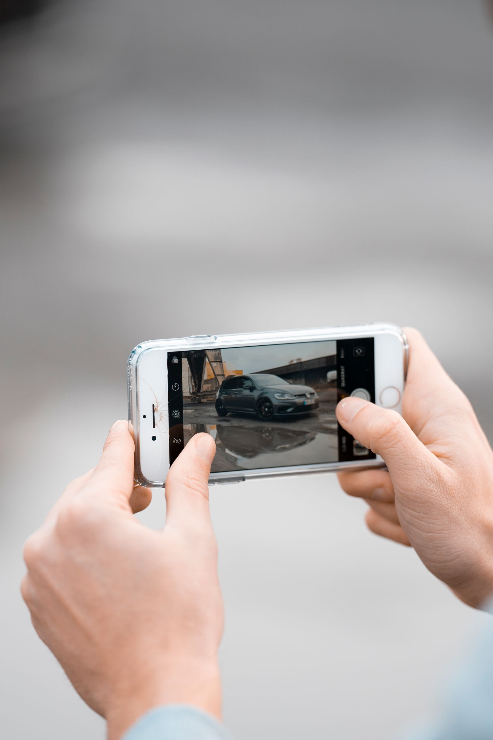Close-up of hands photographing a rental car with a smartphone before drop-off